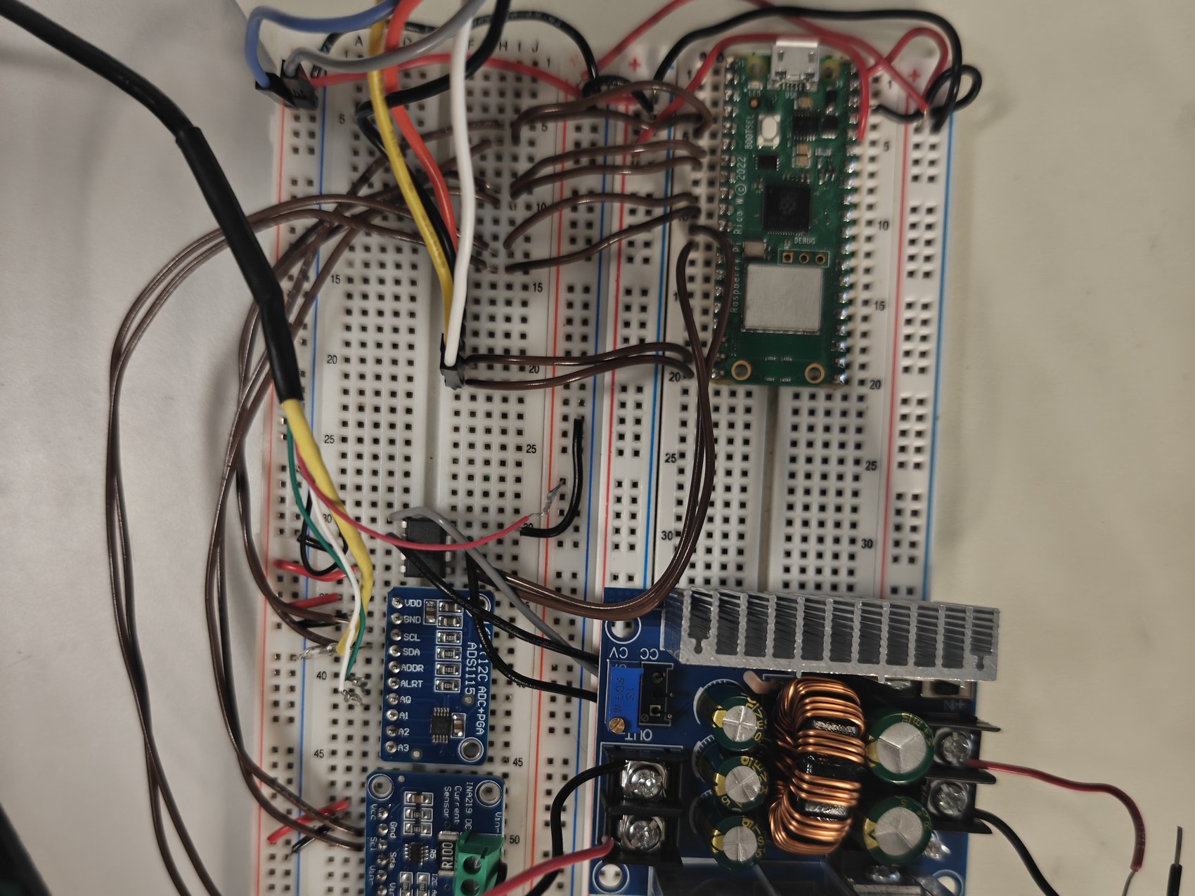 The rig electronics on a breadboard: a Pico W, an ADS1115, a current sensor and a buck converter with its heatsink
