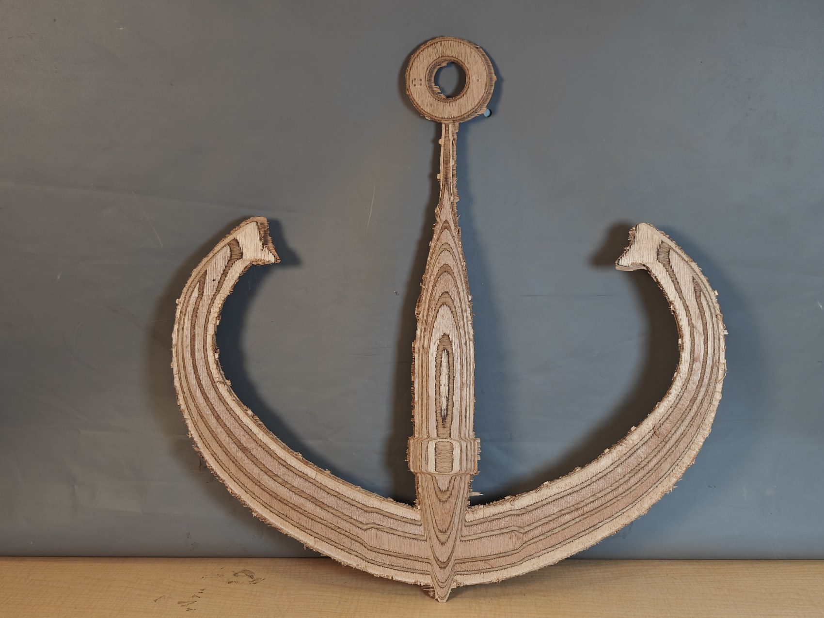 The finished anchor cut from marine plywood, laminations visible at every edge